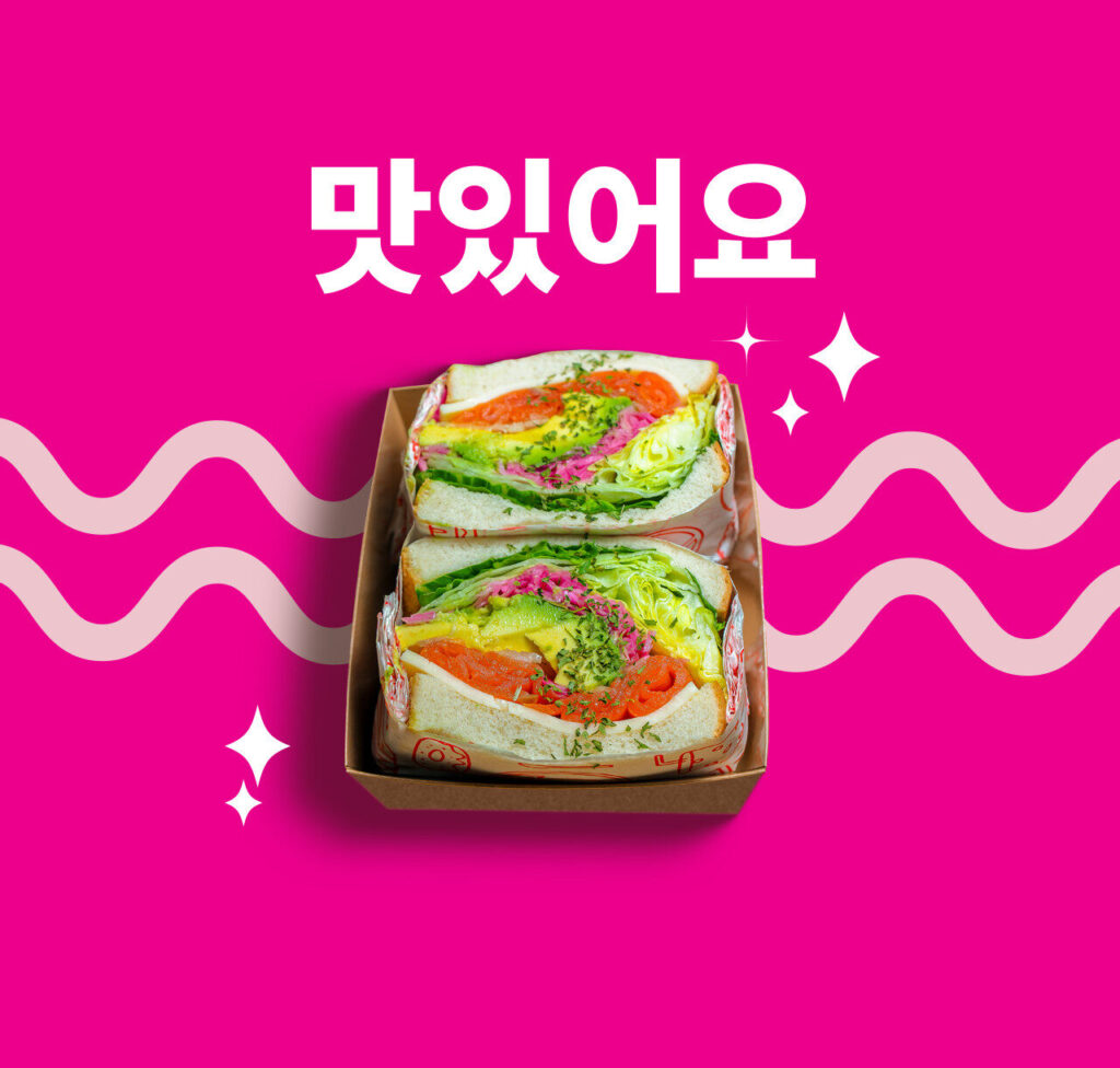 Sandwich coréen Komodo Box avec légumes frais et sauce épicée.